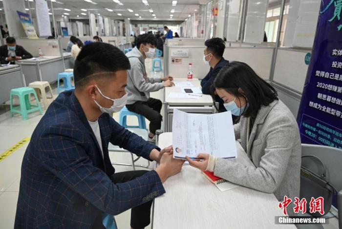 4月14日，招聘者在查看求職者簡(jiǎn)歷。<a target='_blank'  data-cke-saved- >中新社</a>記者 王剛 攝