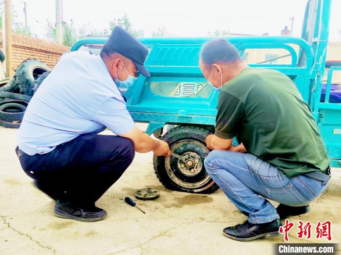 賽旦與民警共同維修三輪摩托車?！∫懒窘?攝